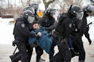 Russian police detain a man as he tries to lay flowers in tribute of Alexei Navalny in St. Petersburg on Saturday.