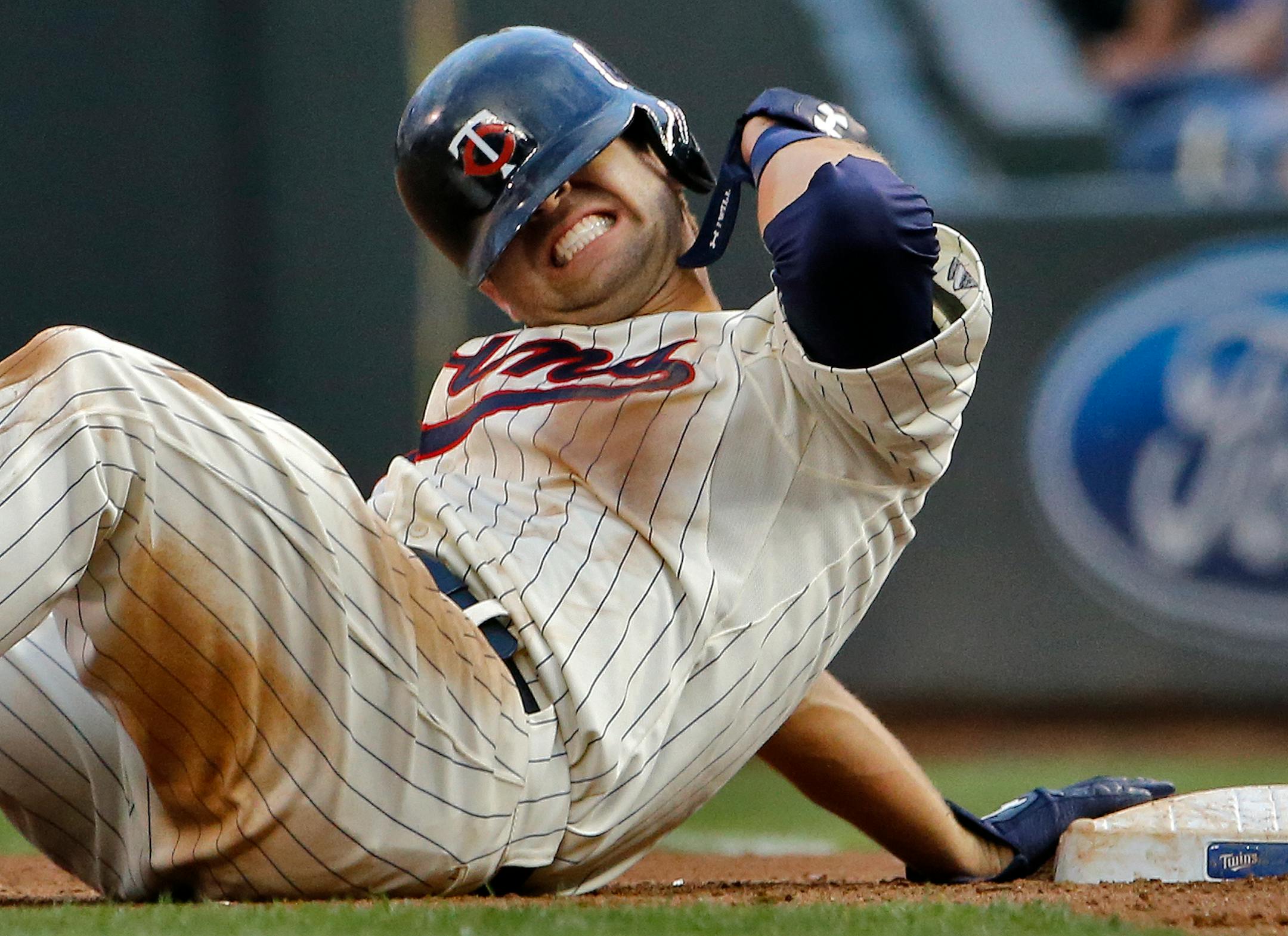 Brian Dozier grimaced after being hit in the back on a fourth inning pick-off attempt against the Brewers.
