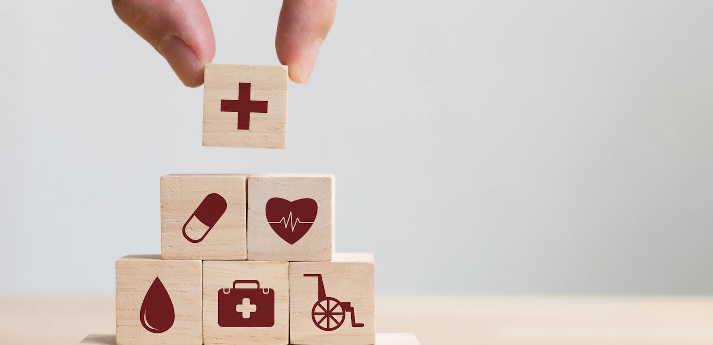 iStock
Hand arranging wood block stacking with icon healthcare medical, Insurance for your health concept