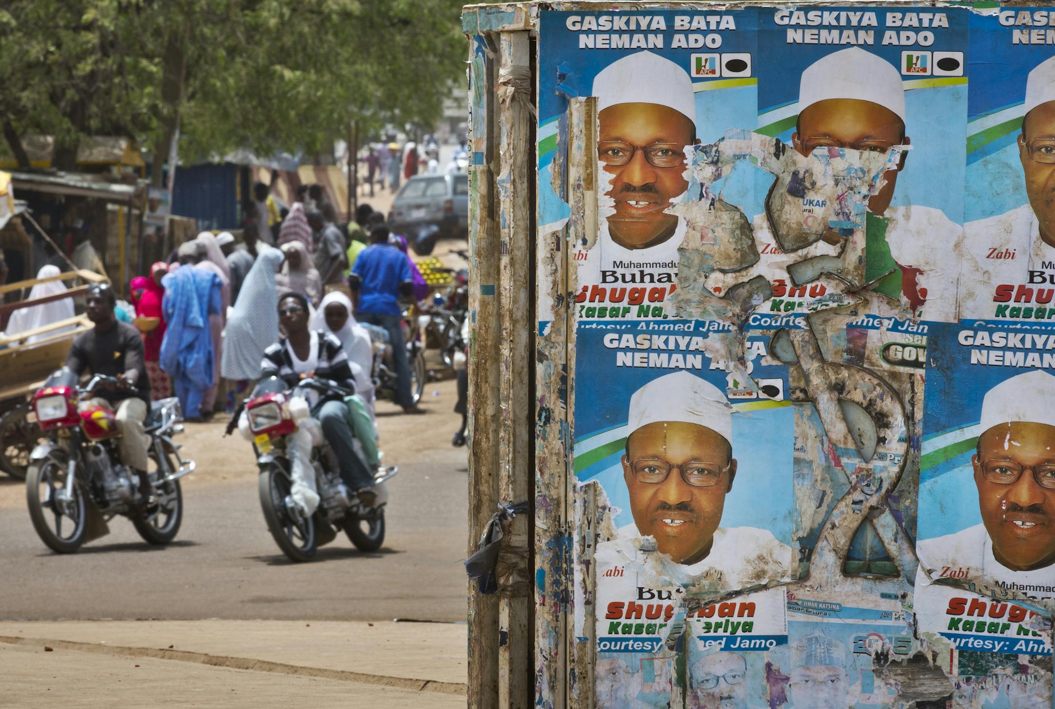 Traffic passes by campaign posters for opposition candidate Gen. Muhammadu Buhari plastered on the centre of a roundabout in Daura, his home town, in Katsina state in northern Nigeria Friday, March 27, 2015. The imam of the Emir's Palace Mosque in Daura called during traditional Friday prayers for worshippers to pray for free and fair elections, which are due to be held on Saturday. (AP Photo/Ben Curtis)