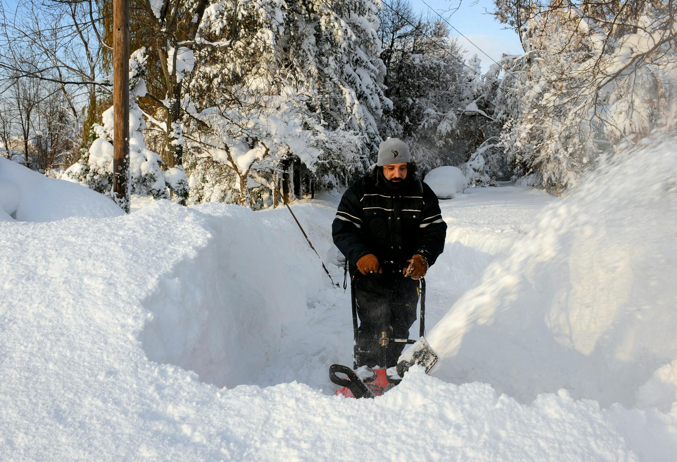 Bob Wilcox clears the snow at the end of his driveway on Bowen Rd. in Lancaster, N.Y. Wednesday, Nov. 19, 2014. A ferocious storm dumped massive piles of snow on parts of upstate New York, trapping residents in their homes and stranding motorists on roadways, as temperatures in all 50 states fell to freezing or below. (AP photo/Gary Wiepert)
