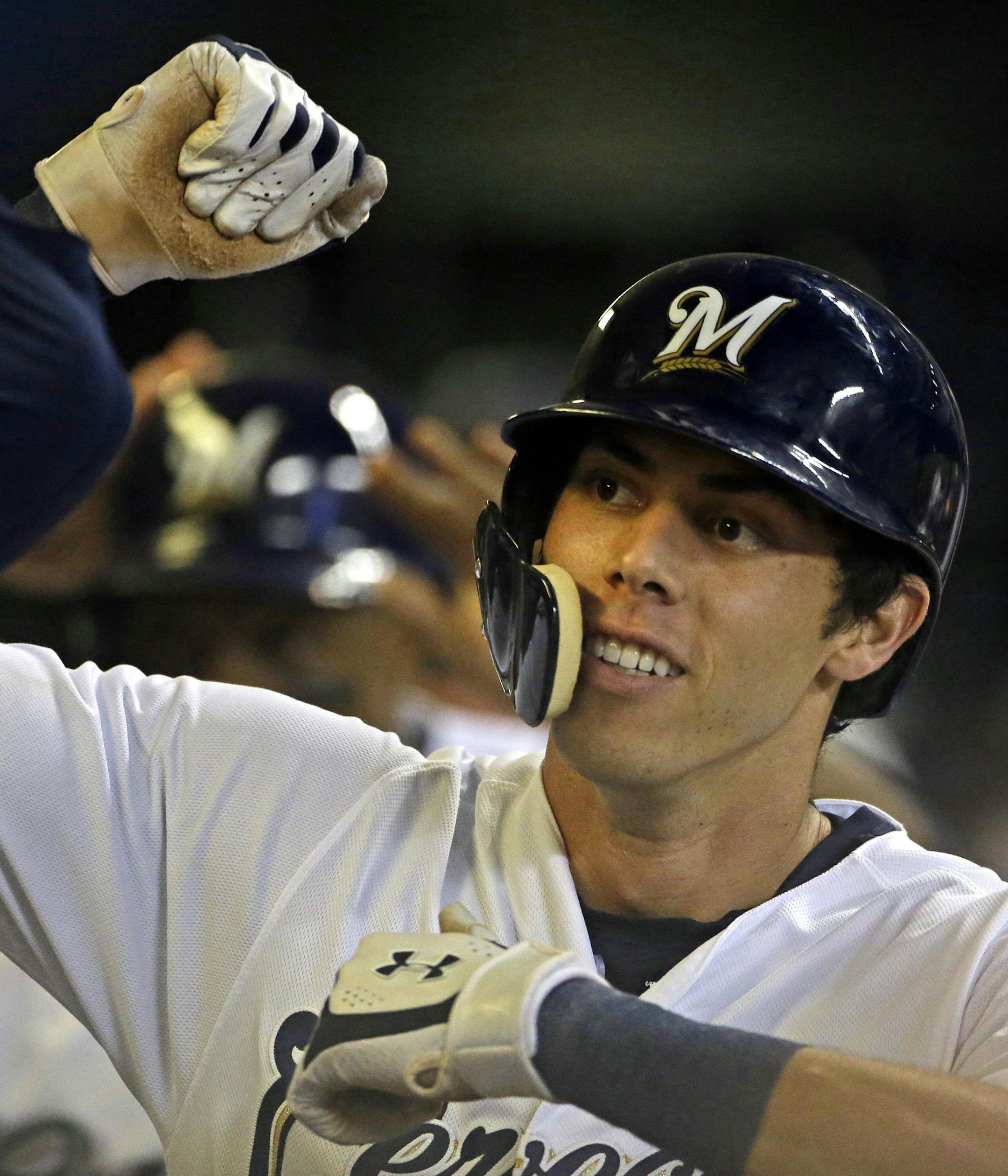 Milwaukee Brewers' Christian Yelich is congratulated by teammates in the dugout after hitting a two-run home run during the fifth inning of a baseball game against the Cincinnati Reds, Monday, Sept. 17, 2018, in Milwaukee. (AP Photo/Aaron Gash) ORG XMIT: MIN2018092420292734