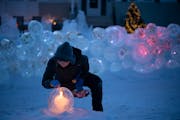 Jennifer Shea Hedberg lit one of her ice luminaries before friends arrived for an outdoor chili dinner on her front patio. ] JEFF WHEELER • jeff.whe