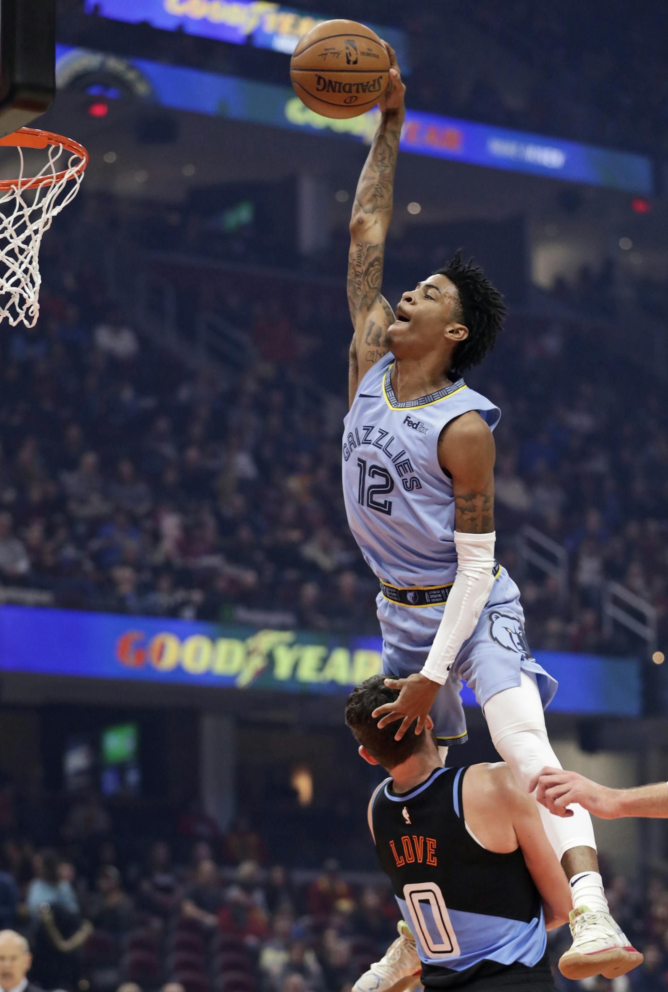 Memphis Grizzlies' Ja Morant (12) drives to the basket against Cleveland Cavaliers' Kevin Love (0) in the first half of an NBA basketball game, Friday, Dec. 20, 2019, in Cleveland. (AP Photo/Tony Dejak)