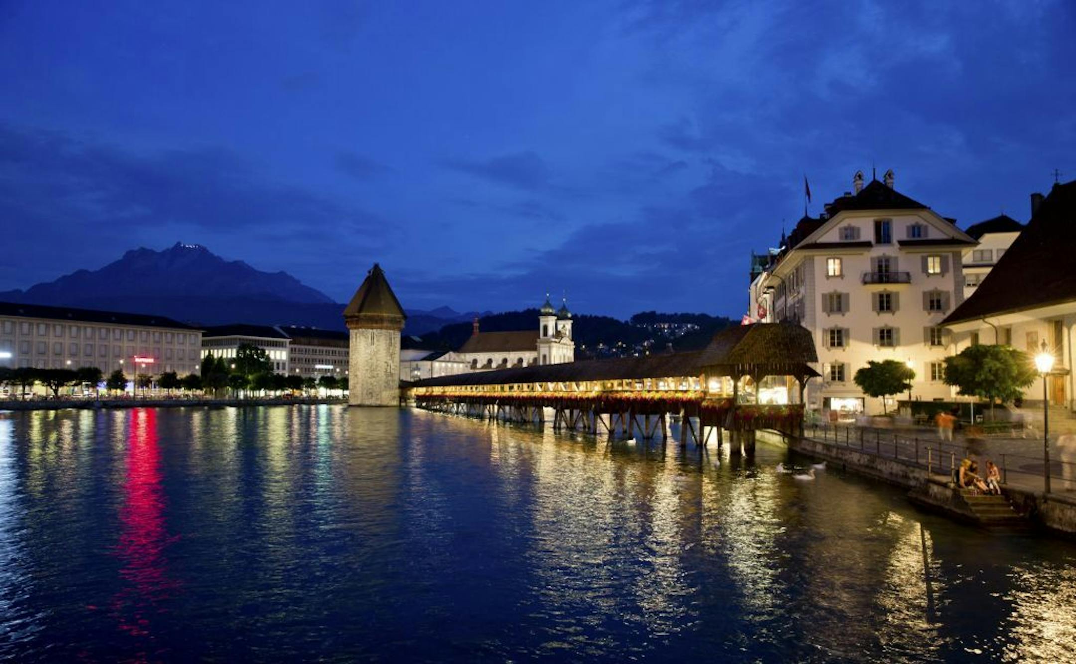 The Chapel Bridge with the Water Tower at the river Reuss in the centre of Lucerne, Switzerland, 19 July 2013. In the back is the Jesuit Church. Photo by: Daniel Karmann/picture-alliance/dpa/AP Images