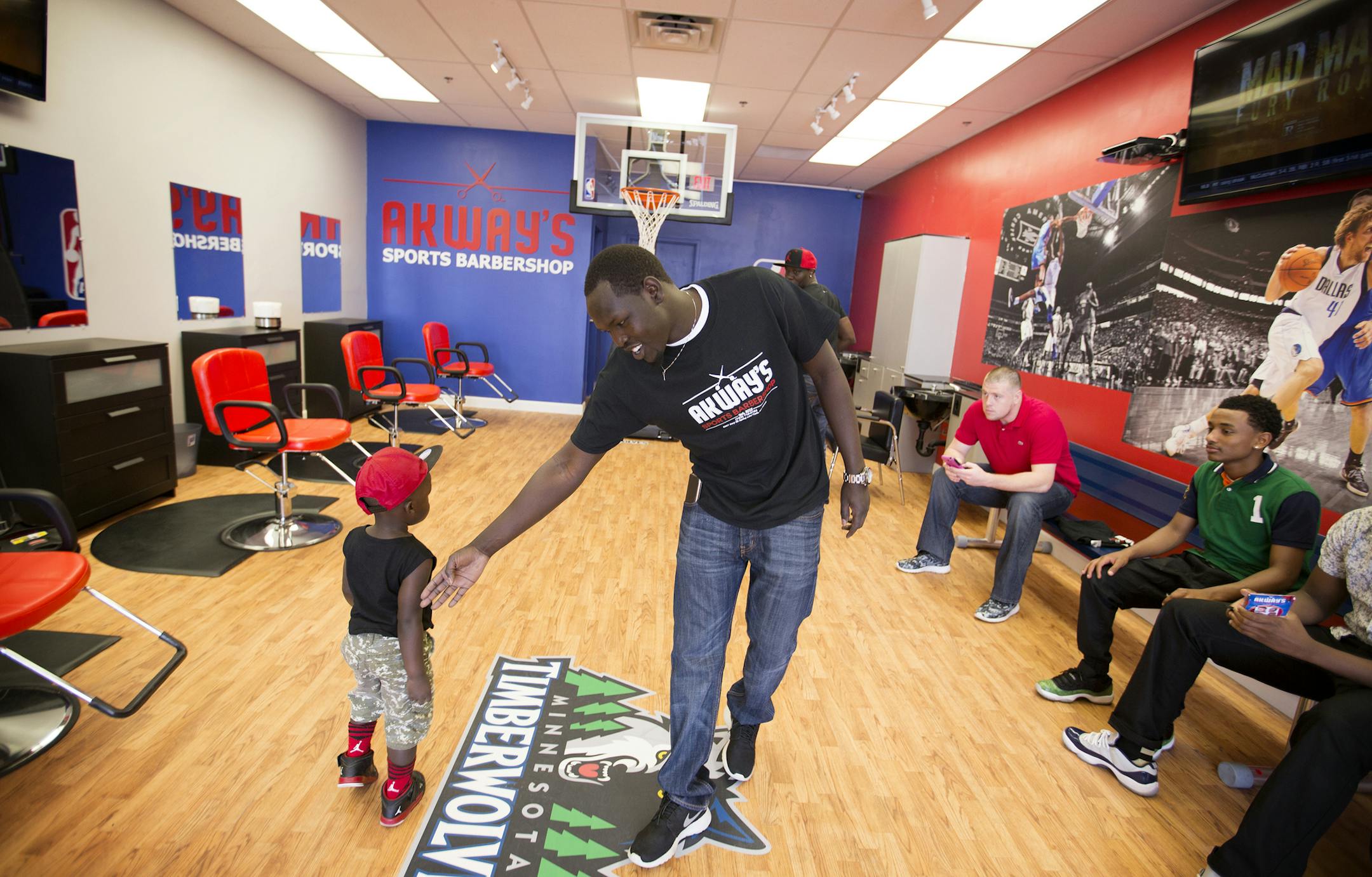 Akeem Akway says hello to his cousin Owar Okado, 2, on the opening day of his new business Akway's Sports Barbershop in Spring Lake Park on Friday, May 8, 2015. LEILA NAVIDI leila.navidi@startribune.com / BACKGROUND INFORMATION: Akeem Akway, a former Fridley basketball player, used to cut his teammates' hair in the locker room.