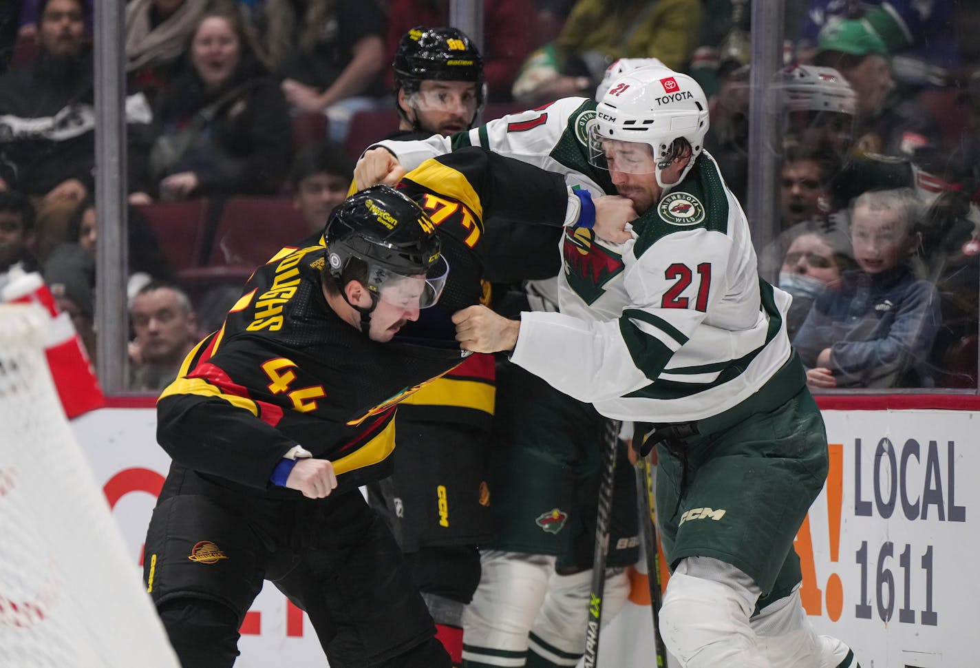 Vancouver Canucks' Kyle Burroughs (44) and Minnesota Wild's Brandon Duhaime (21) fight during the third period of an NHL hockey game Thursday, March 2, 2023, in Vancouver, British Columbia. (Darryl Dyck/The Canadian Press via AP)