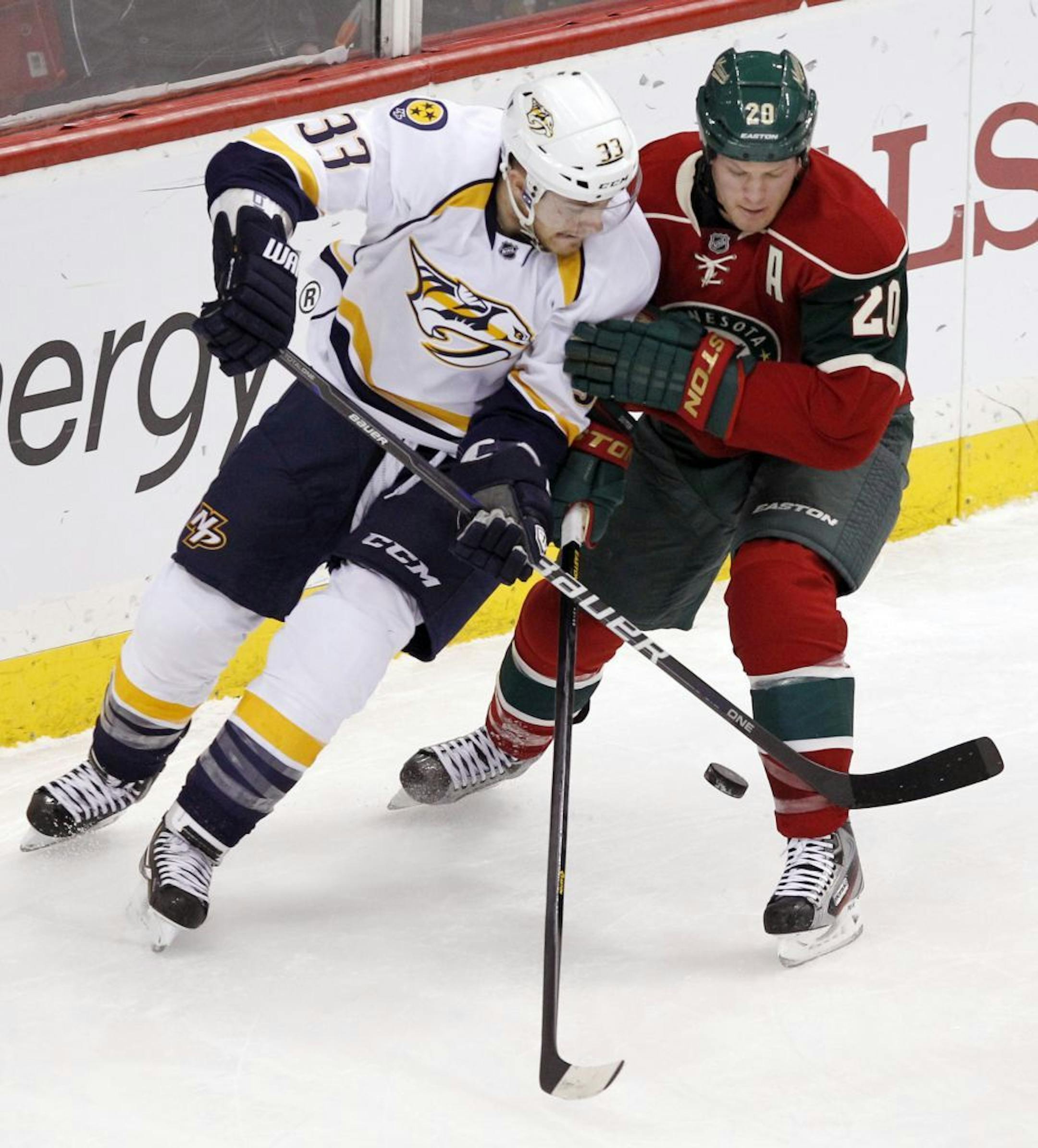 Predators center Colin Wilson and the Wild's Ryan Suter battle for possession.