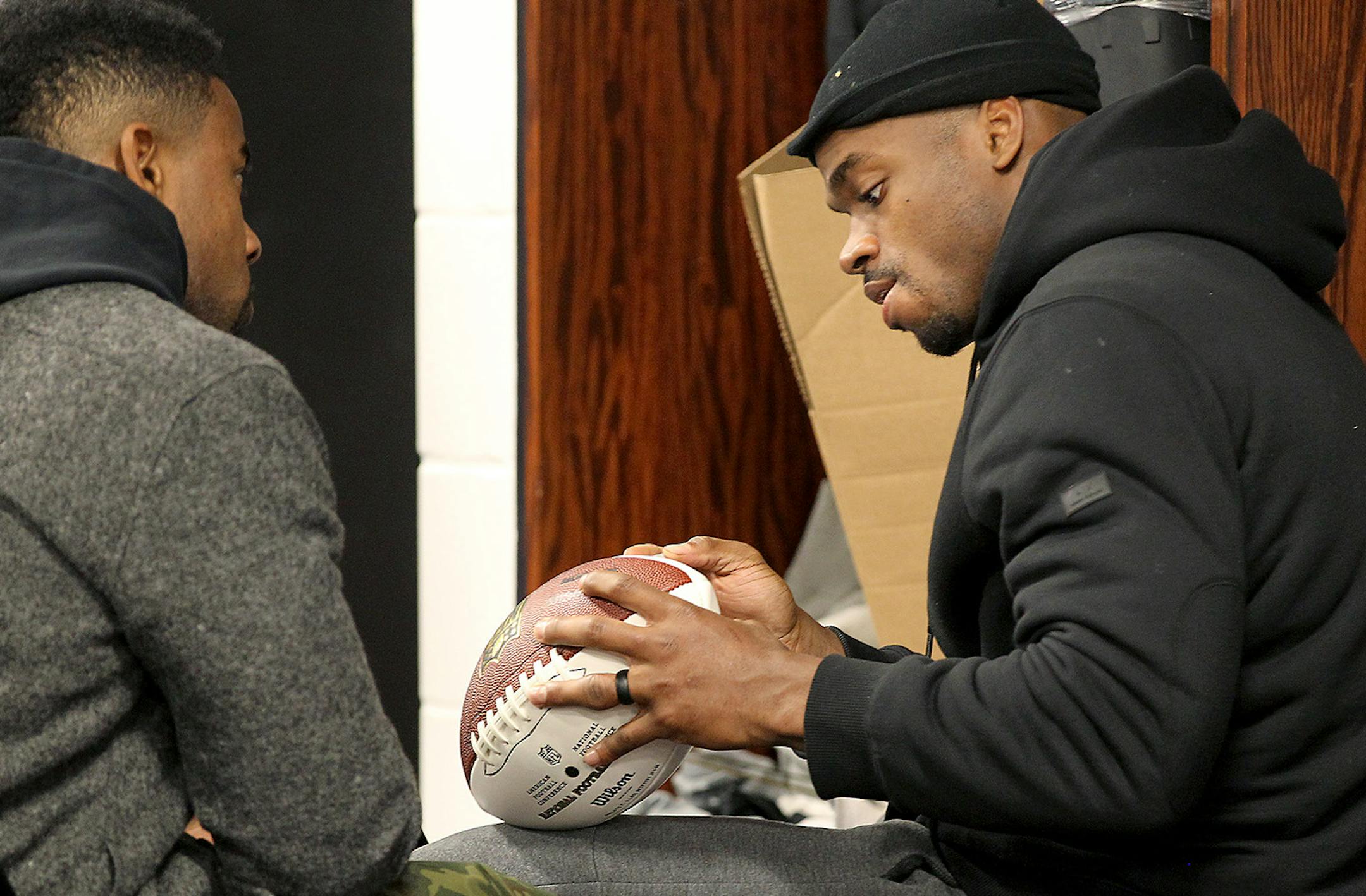 Minnesota Vikings Adrian Peterson, right, signed a football for Antone Exum Jr. in the locker room after being dismissed for the season at Winter Park, Monday, January 11, 2016 in Eden Prairie, MN. ] (ELIZABETH FLORES/STAR TRIBUNE) ELIZABETH FLORES &#x2022; eflores@startribune.com