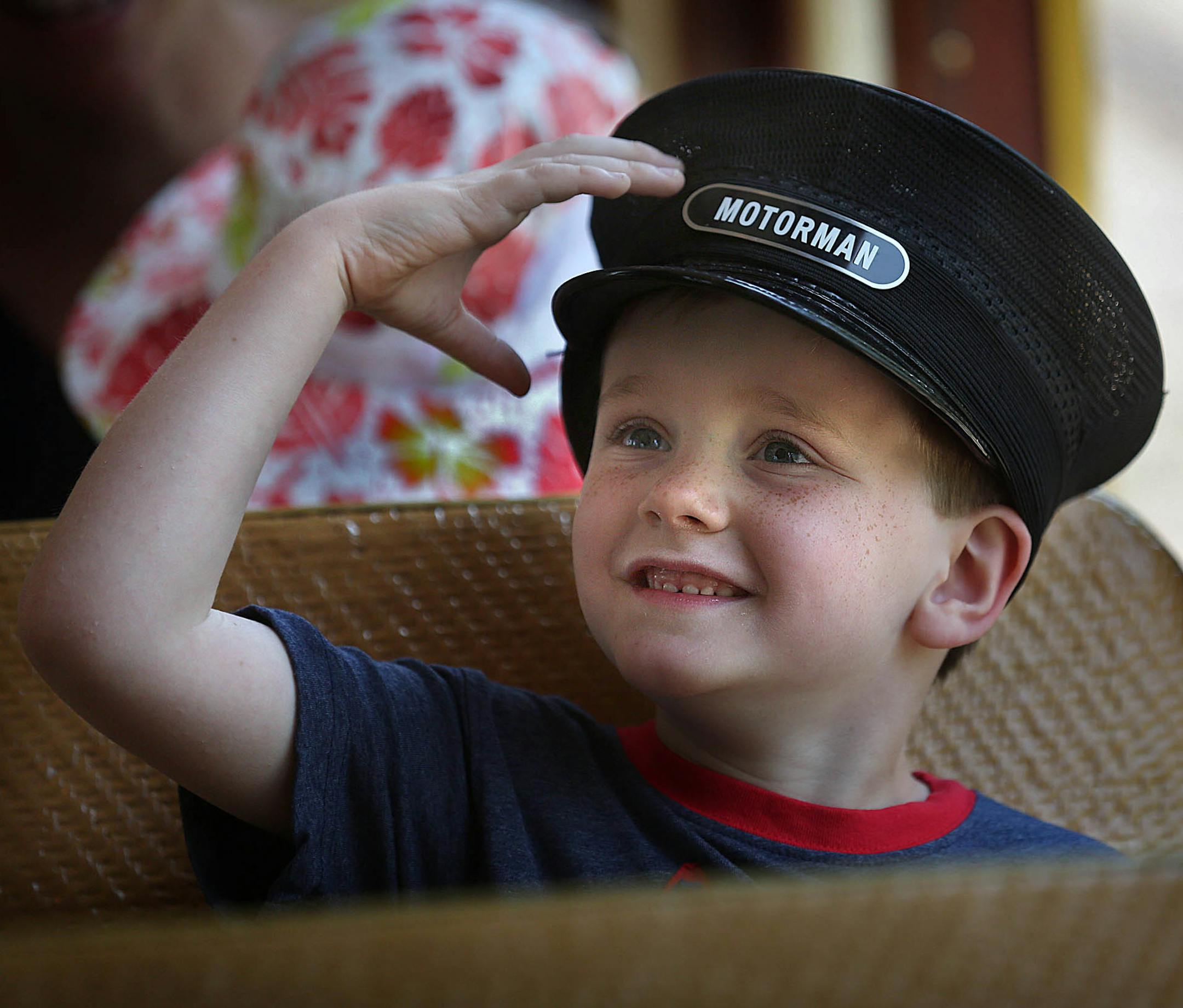 Quinn Deck, 6, Minneapolis, enjoyed his ride. He sported a hat lent to him by conductor Bill Preiss. The bright yellow streetcars present an invitation to ride to kids of all ages.
