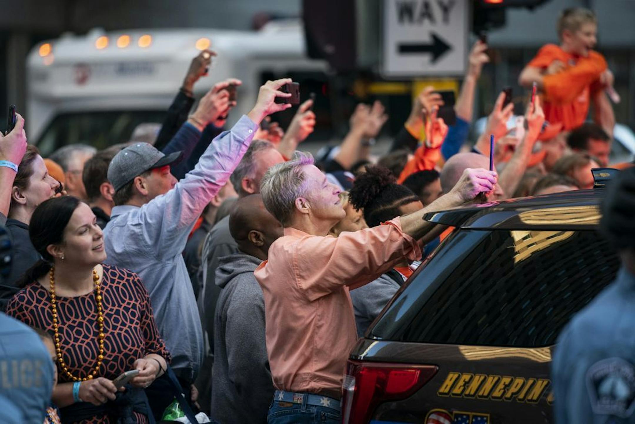 University of Virginia fans take photos and video outside the Marquette Hotel in downtown Minneapolis as their basketball team boards the bus.