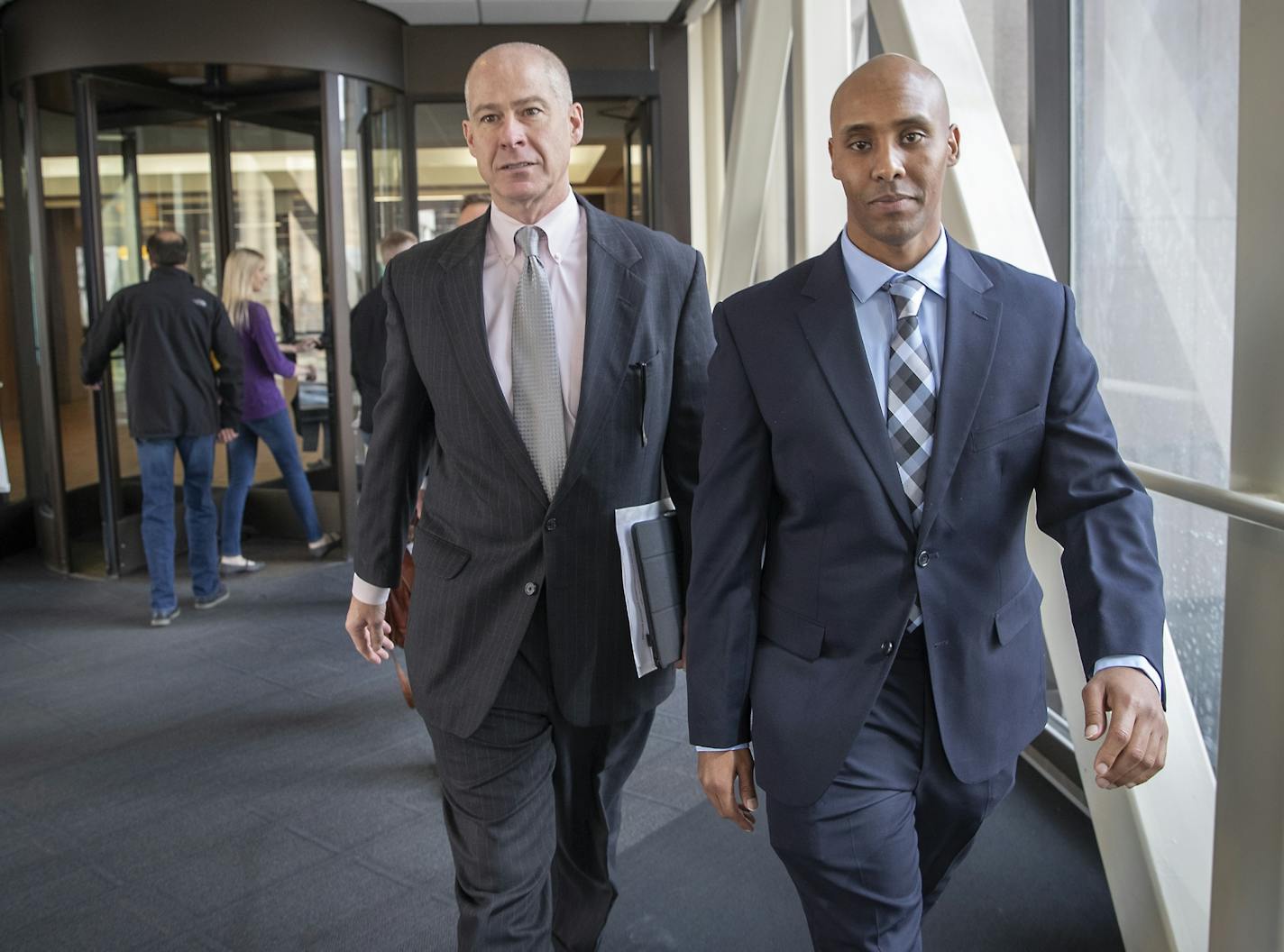 Attorney Thomas Plunkett, left, and former Minneapolis police officer Mohamed Noor made their way out of a court hearing, Friday, March 29, 2019 at the Hennepin County Government Center.