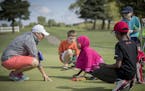 Angie Ause, of St. Paul, a PGA instructor, led a group of blind and visually impaired children to feel the green on a golf course during a golf lesson