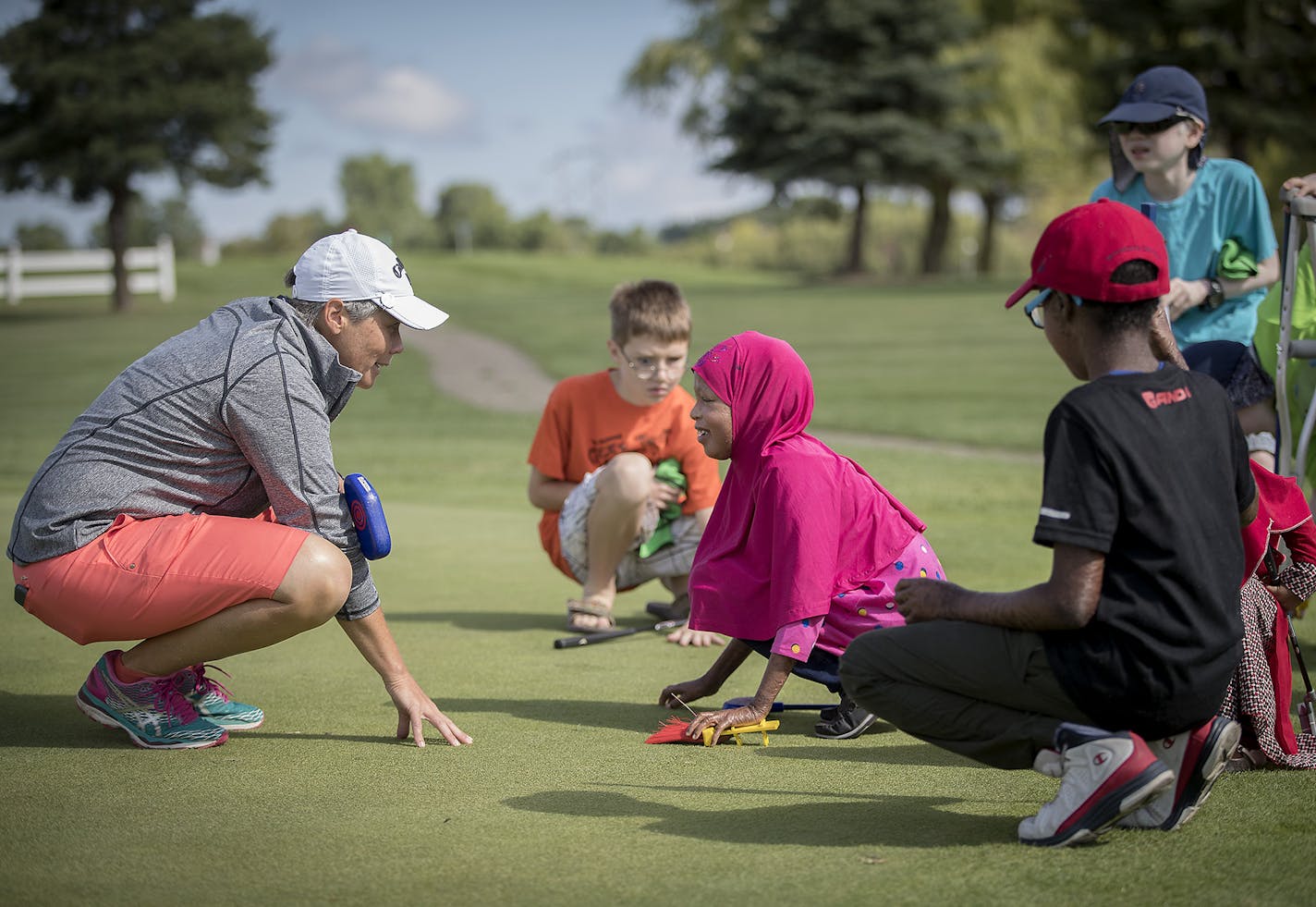 Angie Ause, of St. Paul, a PGA instructor, led a group of blind and visually impaired children to feel the green on a golf course during a golf lesson at Oak Marsh Golf Course, Monday, July 24, 2017 in Oakdale, MN. ] ELIZABETH FLORES &#xef; liz.flores@startribune.com