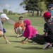 Angie Ause, of St. Paul, a PGA instructor, led a group of blind and visually impaired children to feel the green on a golf course during a golf lesson