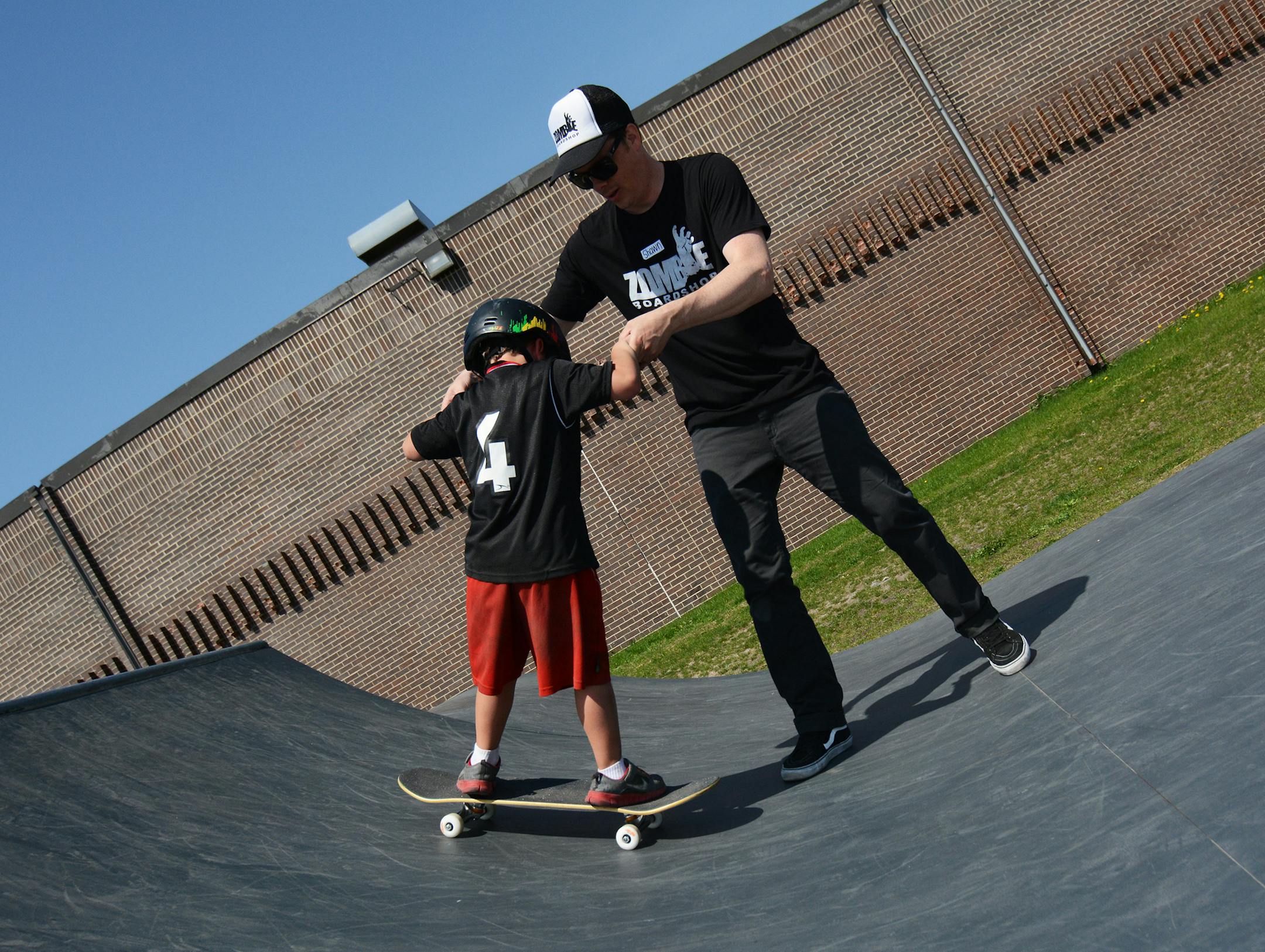 Shawn Solem, owner of Zombie Boardshop in Burnsville assisted Luke Buri, 5, of Burnsville. Photo by Liz Rolfsmeier, Special to the Star Tribune