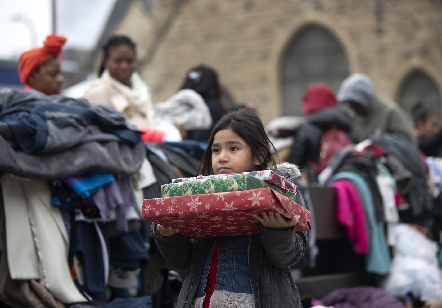 A 5-year-old girl held on to Christmas presents that were donated after a four-alarm fire at the Francis Drake Hotel apartments broke out early Christmas Day morning. The girl lived at the Drake Hotel with her family.