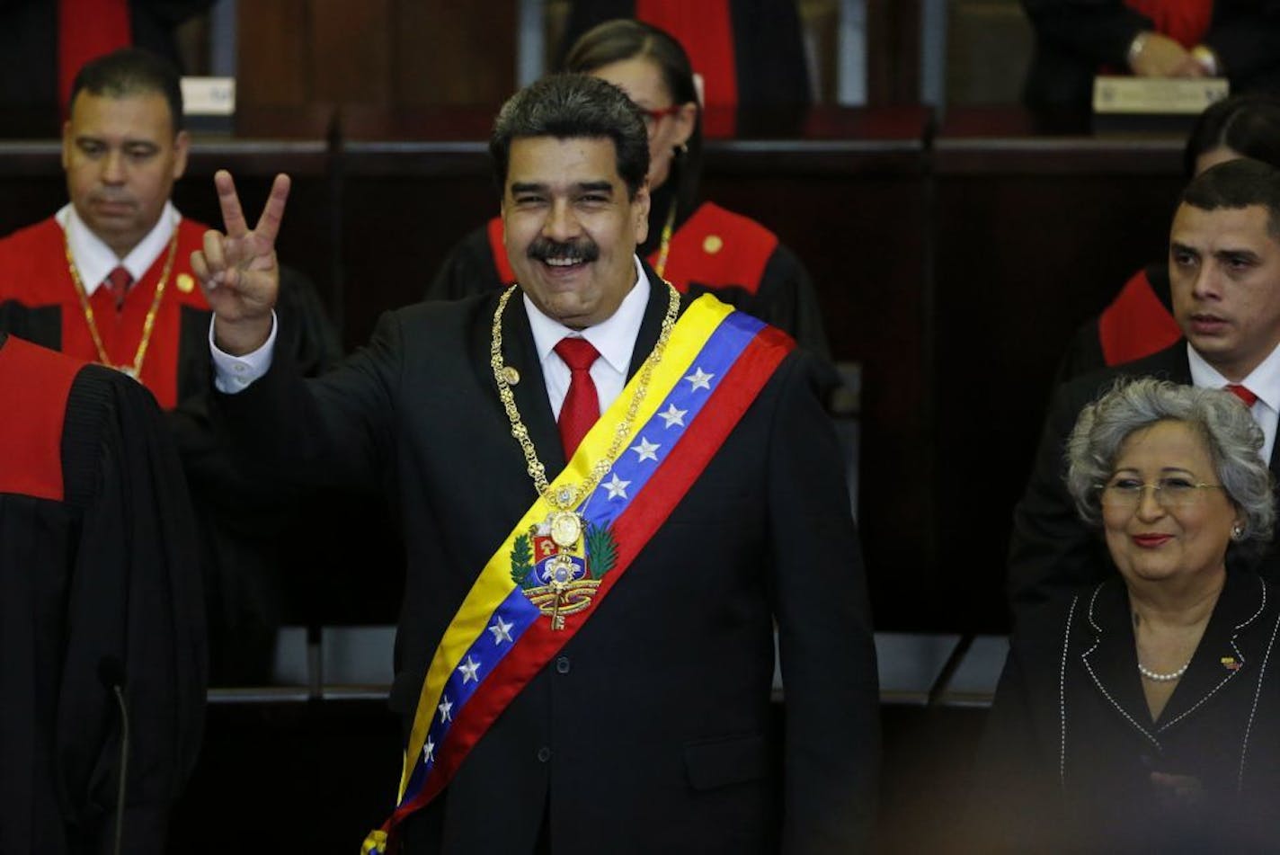 FILE - In this Jan. 10, 2019 file photo, Venezuela's President Nicolas Maduro flashes a vee for victory during his swearing-in ceremony at the Supreme Court in Caracas, Venezuela. Maduro was sworn in for a second term as president, but most Latin American countries, the United States and Canada denounced his government as illegitimate, arguing his re-election was a farce.