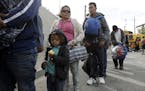 Central American migrants wait in line for a meal at a shelter Wednesday, Nov. 14, 2018, in Tijuana, Mexico. Migrants in a caravan of Central American