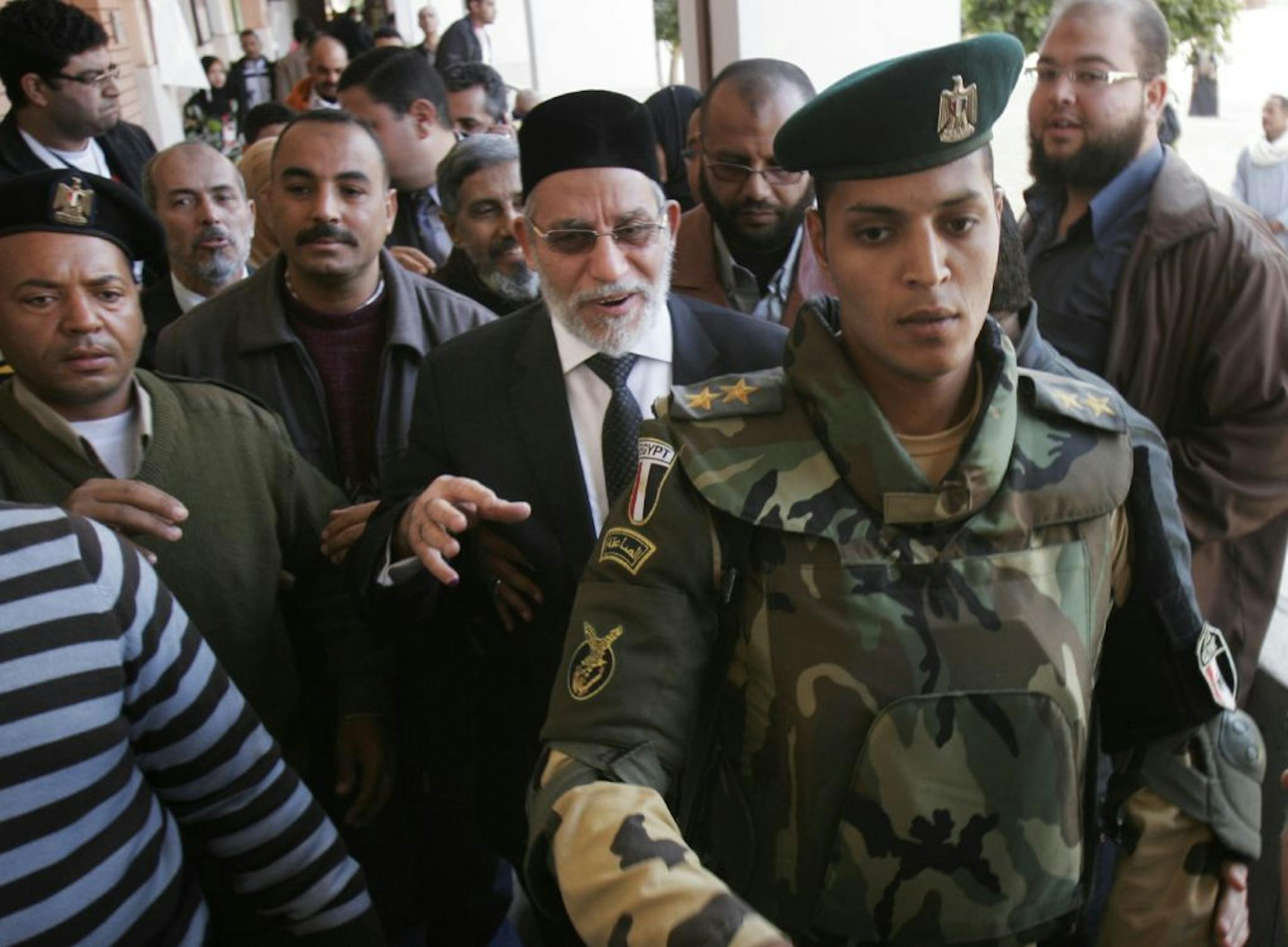 Muslim Brotherhood leader Mohammed Badie, center, is escorted by Egyptian soldiers inside a polling station in Beni Suef, Egypt, Thursday, Dec. 15, 2011.