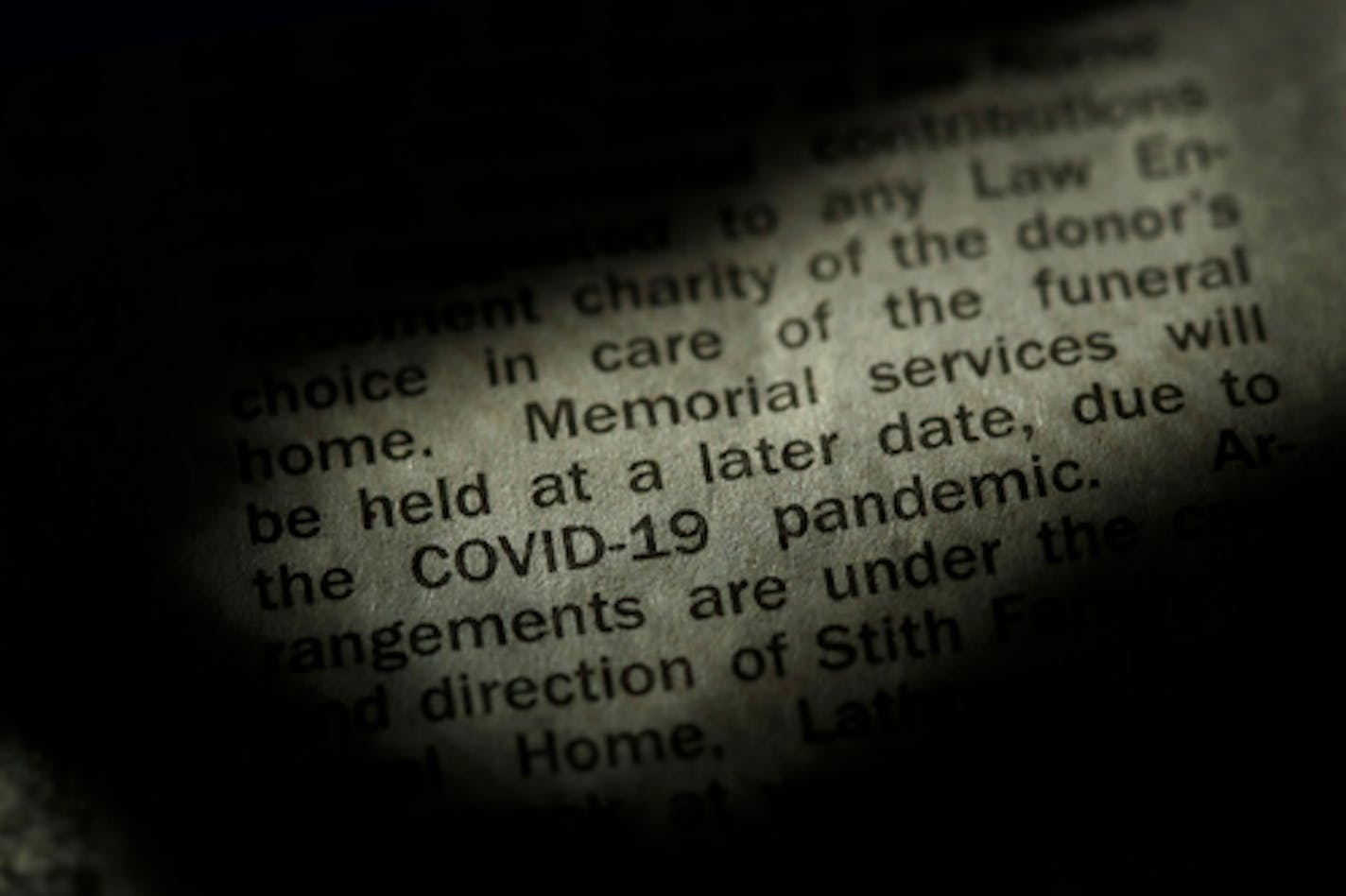 An obituary in the Kansas City Star newspaper details the effect of the COVID-19 pandemic on traditional funeral services, Sunday, April 5, 2020, in Overland Park, Kan. Most funerals now are either small private services with a public memorial service sometime in the distant future or no public service at all in response to social distancing and stay-at-home orders implemented in an effort to stem the spread of the new coronavirus. (AP Photo/Charlie Riedel)