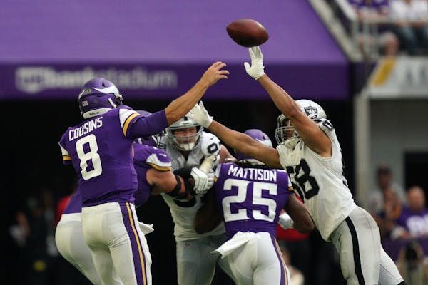 Minnesota Vikings quarterback Kirk Cousins (8) threw under pressure from Oakland Raiders linebacker Kyle Wilber (58) in the third quarter.