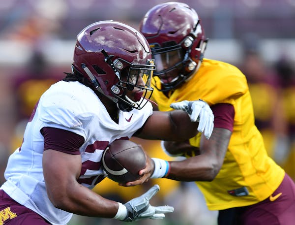 Gophers running back Kobe McCrary (22) ran the ball off a handoff by quarterback Denny Croft (11) during Saturday's scrimmage. ] (AARON LAVINSKY/STAR 