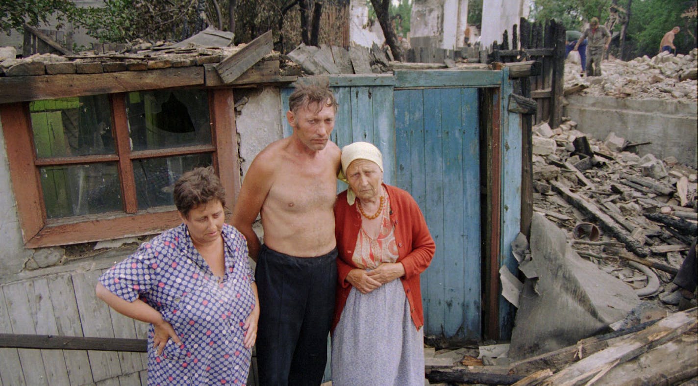 A miner's family in densely mined Kirovsk, Siberia, in front of the debris of the burnt barrack where they have lived all their lives.