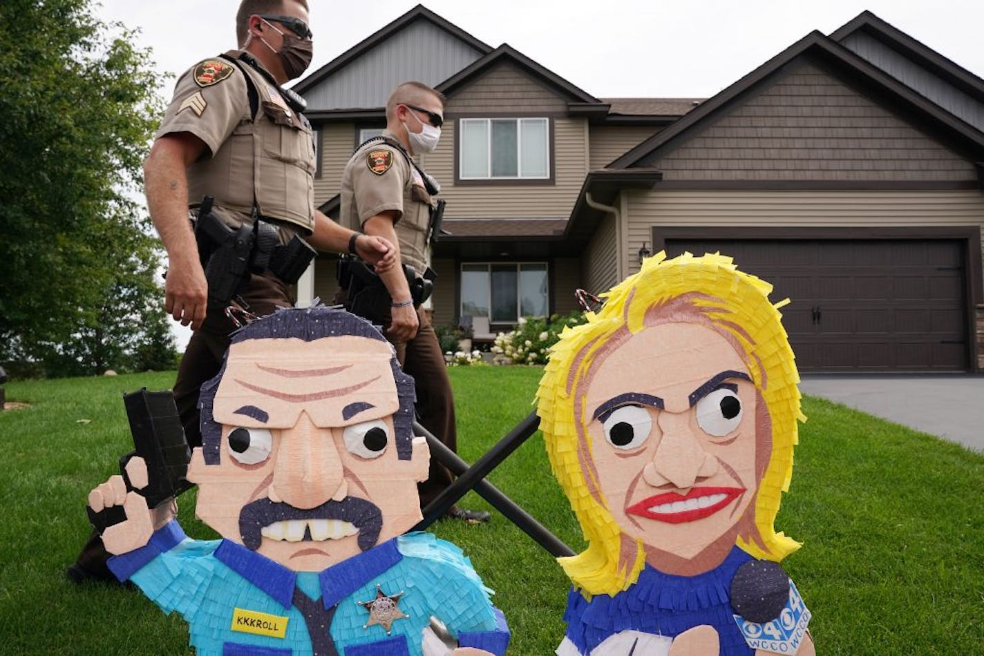 Washington County Sheriff's deputies walked past a pair of effigies of Minneapolis Police Federation president Bob Kroll and his wife WCCO reporter Liz Collin during a protest Sunday, Aug. 16