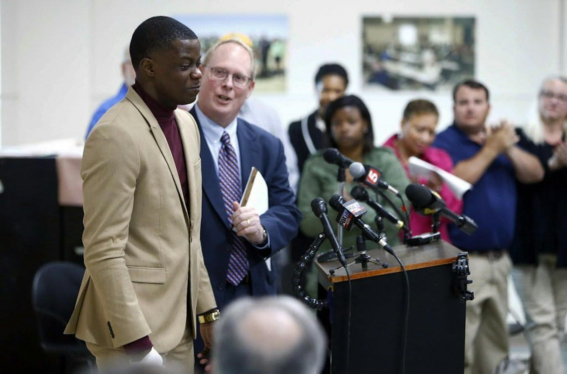 Waffle House hero James Shaw, left, gets a standing ovation after speaking during a press conference Sunday, April 22, 2018, in Nashville, Tenn. Shaw wrestled the gun from the shooting suspect. Behind Shaw is police spokesman Don Aaron.