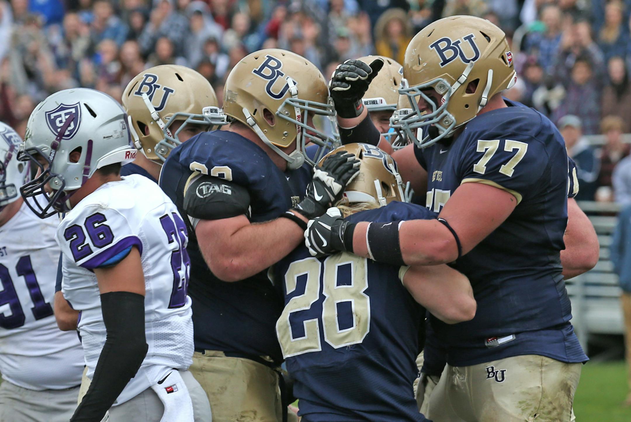 Bethel University running back Marshall Klitzke was mobbed by scoring against St. Thomas earlier this season.