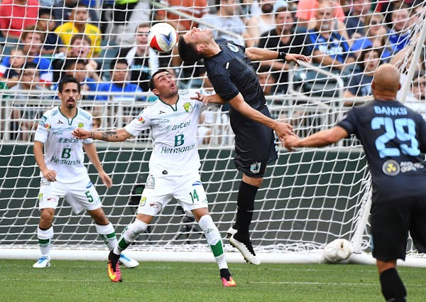 Minnesota United FC forward Christian Ramirez (21) was unable to score off a corner kick while being defended by Club Leon's Miguel Ibarra in the firs
