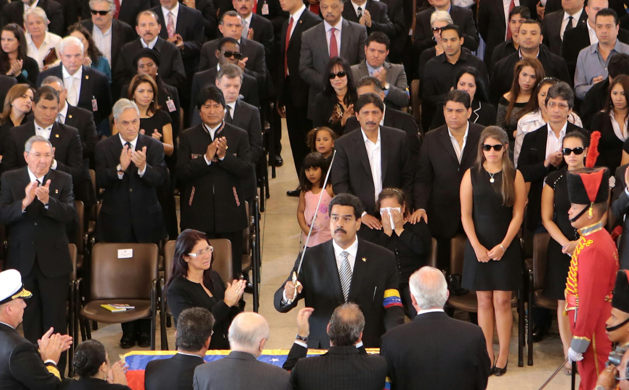 In this photo released by Miraflores Press Office, Venezuela's Vice President Nicolas Maduro holds up a replica of Simon Bolivar's sword next to the flag-draped coffin of Venezuela's late President Hugo Chavez during his funeral ceremony at the military academy in Caracas, Venezuela, Friday, March 8, 2013. Chavez died on March 5 after a nearly two-year bout with cancer. (AP Photo/Miraflores Press Office)
