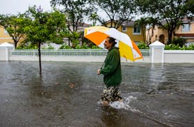 Drew Donner walks down Taft Street as heavy rain floods the nearby neighborhood  on Wednesday, June 12, 2024, in Hollywood, Fla. The annual rainy seas