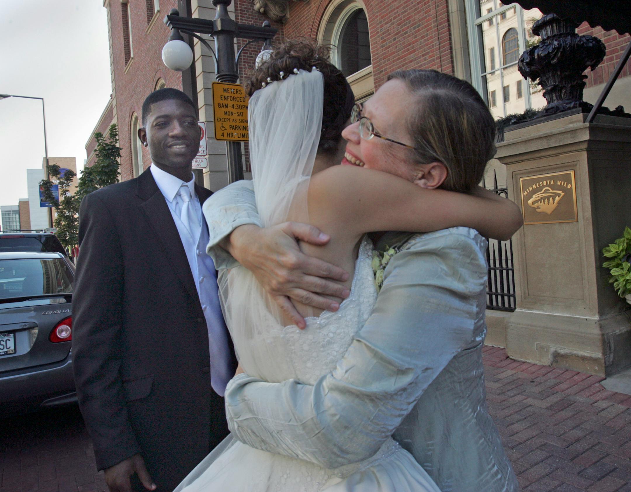 Lee Dean, (right) embraces her daughter Elizabeth, as the groom, Steve Nson, ( left) looks on.