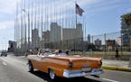 An old car passes in front of the U.S Embassy in Havana, Cuba, on March 17, 2016, prior to a visit by U.S. President Barack Obama.