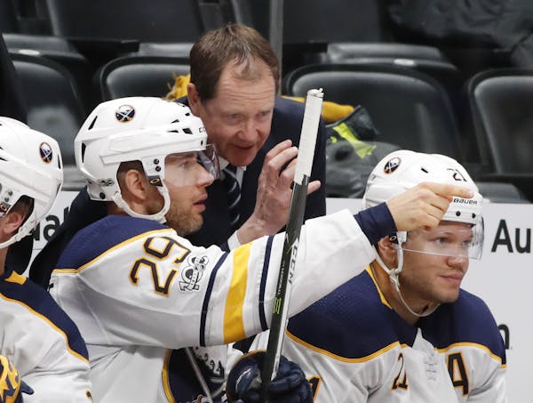 Buffalo Sabres right wing Jason Pominville, front, confers with head coach Phil Housley.
