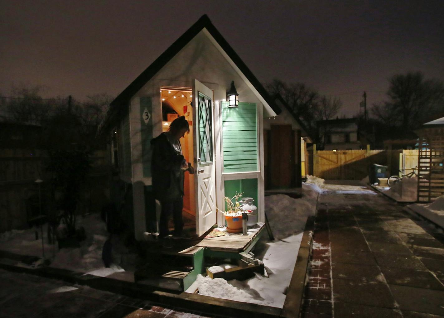 Four formerly homeless people, including a couple, have settled into a cluster of tiny houses they helped build in Madison along with members of Occupy Madison. Here, Betty Ybarra, 49, who shares a tiny house with her partner, closes the door to their tiny house in the OM village before walking into a community center where there are bathrooms, a kitchen, as well as a shop and art studio Tuesday, March 3, 2015, in Madison, WI.](DAVID JOLES/STARTRIBUNE)djoles@startribune.com Three men and a woman