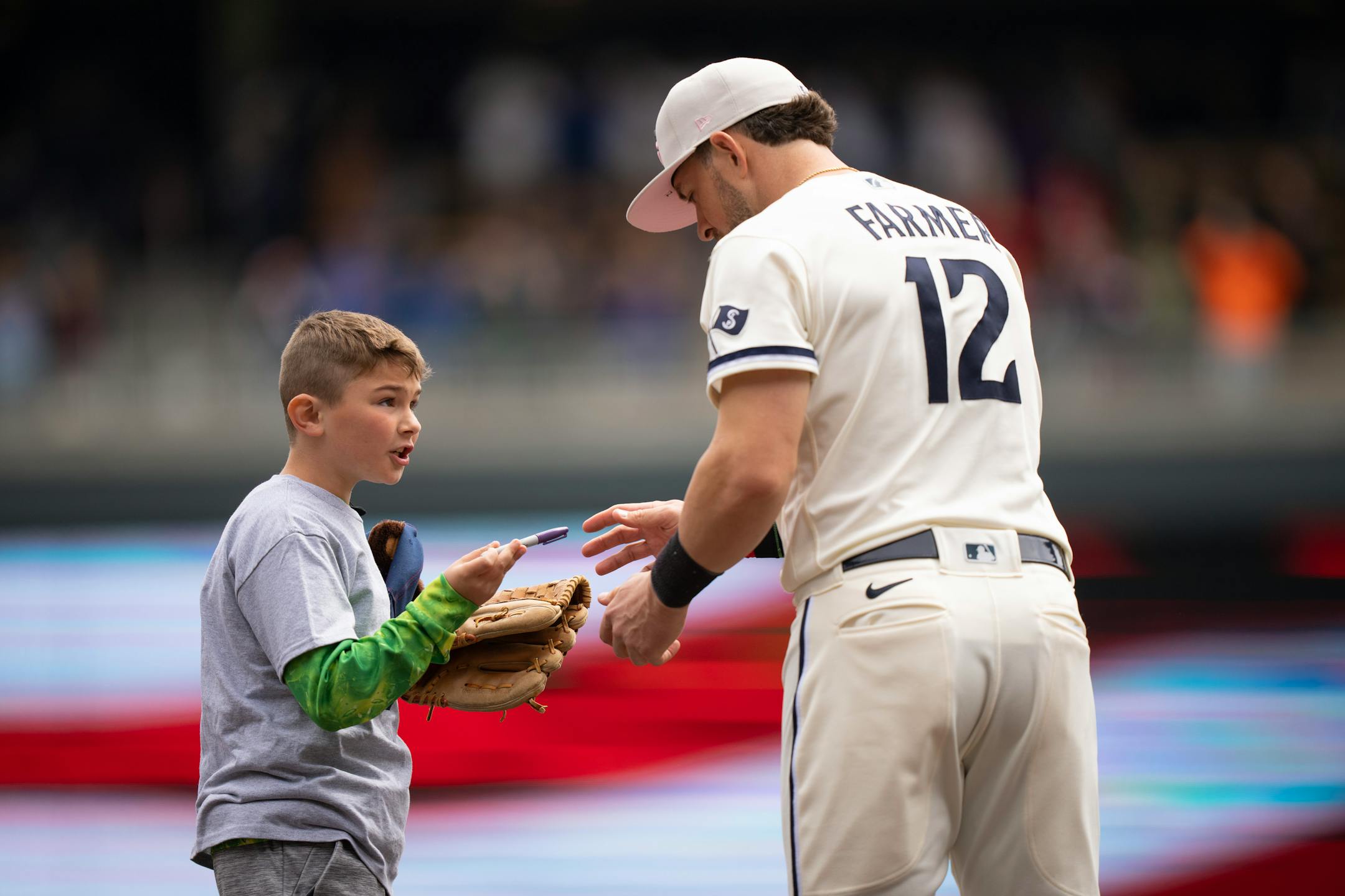 A kid got an autograph from Minnesota Twins third baseman Kyle Farmer after standing next to him for the national anthem.
