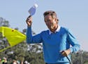 Bernhard Langer, of Germany, tips his cap after putting out on the 18th hole during the third round of the Masters golf tournament Saturday, April 9, 