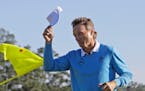 Bernhard Langer, of Germany, tips his cap after putting out on the 18th hole during the third round of the Masters golf tournament Saturday, April 9, 