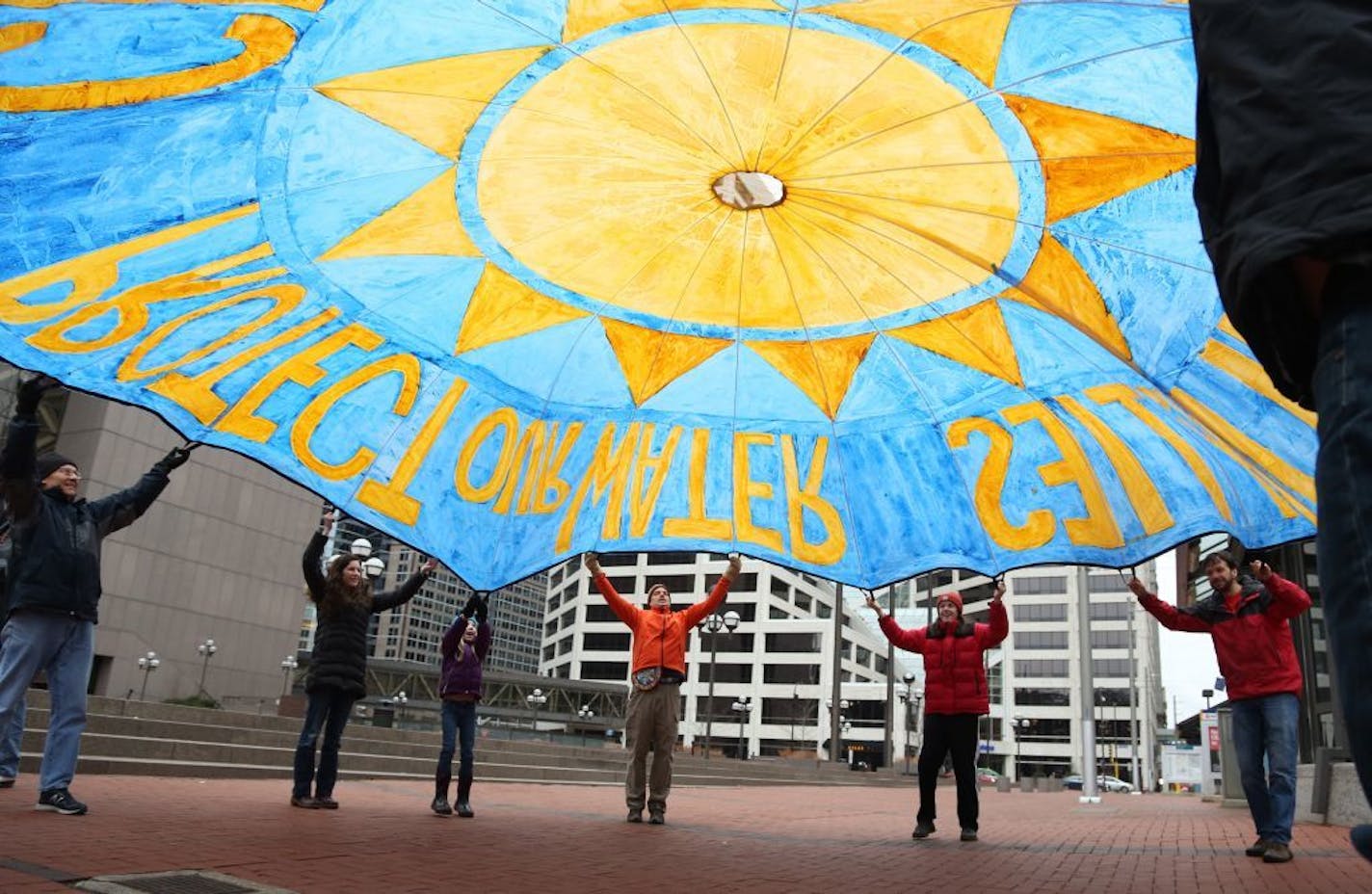 Protesters practiced with a parachute Saturday in downtown Minneapolis as part of marches worldwide to mark the climate talks.