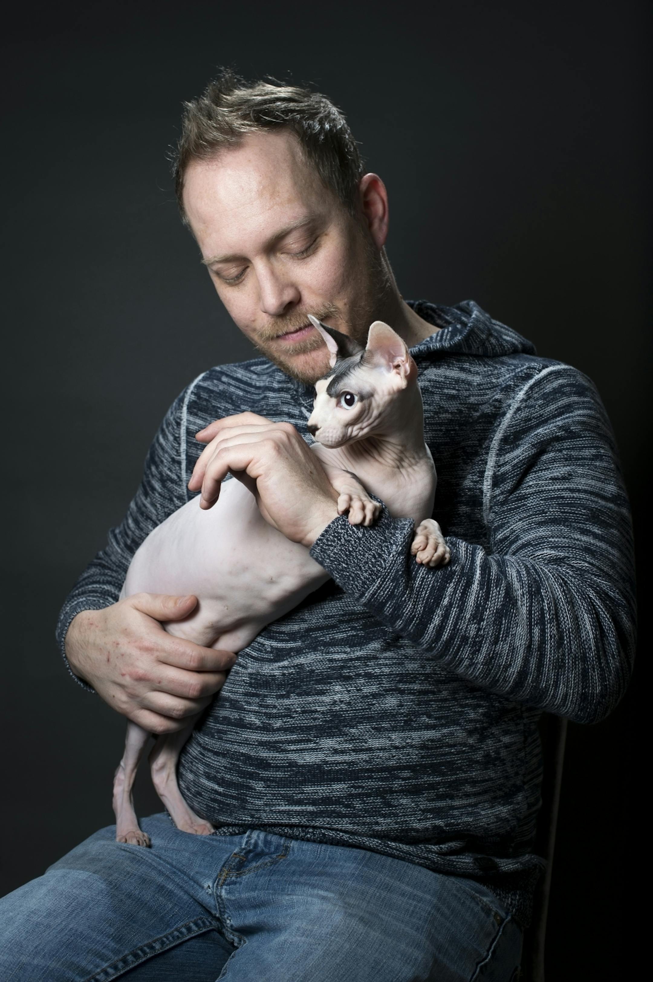 Brian Tripp holds his Sphynx, named Sigur, in his home on Thursday.