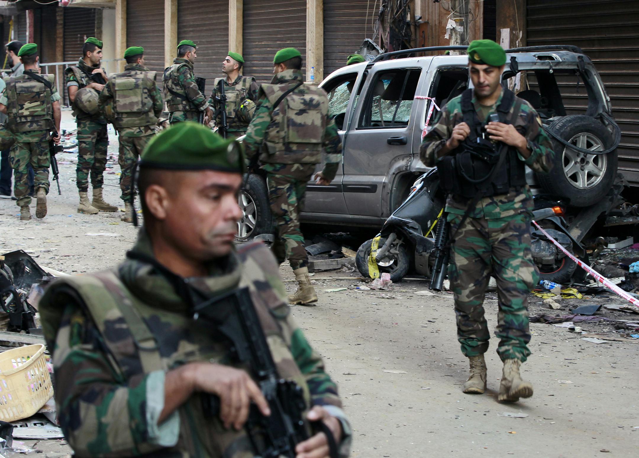 Lebanese army soldiers stand guard at the site of Thursday's twin suicide bombings in Burj al-Barajneh, southern Beirut, Lebanon, Friday, Nov. 13, 2015. Schools and universities across Lebanon were shuttered Friday as the country mourned victims of twin suicide bombings that struck a crowded neighborhood south of the capital. (AP Photo/Bilal Hussein) ORG XMIT: MIN2015111810560737