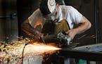A worker uses a grinder on a welding project at Code Welding in Blaine, Minn. [Star Tribune file photo]