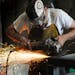 A worker uses a grinder on a welding project at Code Welding in Blaine, Minn. [Star Tribune file photo]