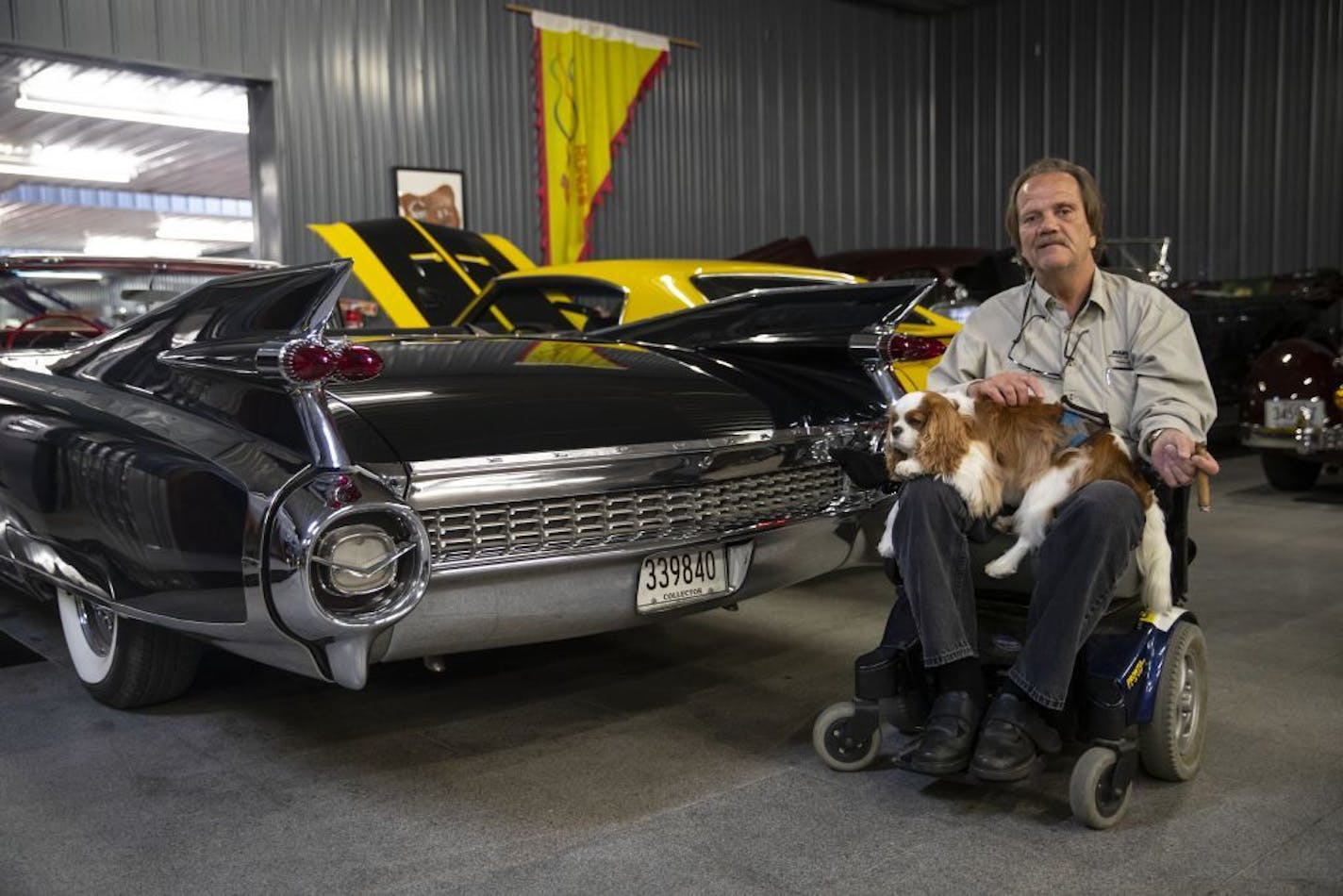 Warroad Mayor Bob Marvin posed for a portrait with his dog in "The Shed". Bob is an avid antique car collector and allows the public to come in and take a look at his collection whenever they'd like.