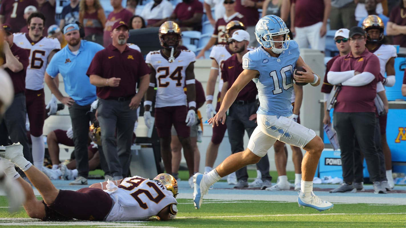 Minnesota defensive lineman Danny Striggow (92) dives but misses North Carolina quarterback Drake Maye (10) who runs the ball during the second half of an NCAA college football game, Saturday, Sept. 16, 2023, in Chapel Hill, N.C. (AP Photo/Reinhold Matay)