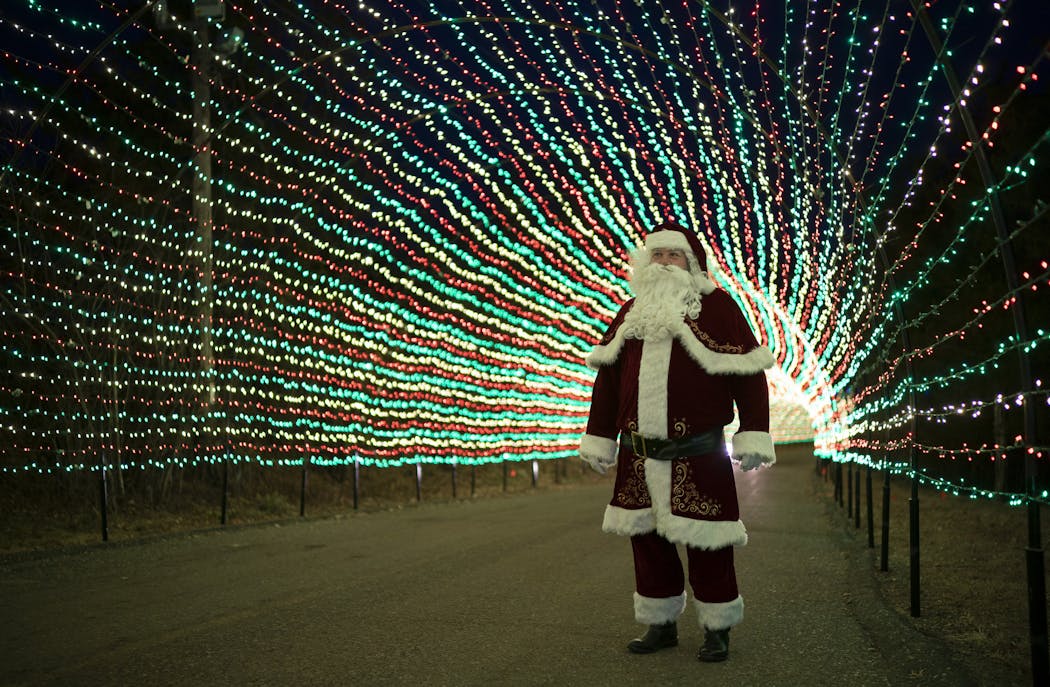Santa, as portrayed by Lloyd Larrieu, in the 500-foot long entrance tunnel lit with 220,000 lights at Sam’s Christmas Village in Somerset, Wis.