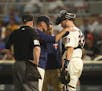 Minnesota Twins catcher Mitch Garver (23) spoke with manager Paul Molitor and a trainer after being hit by a foul ball in the second inning. He left t